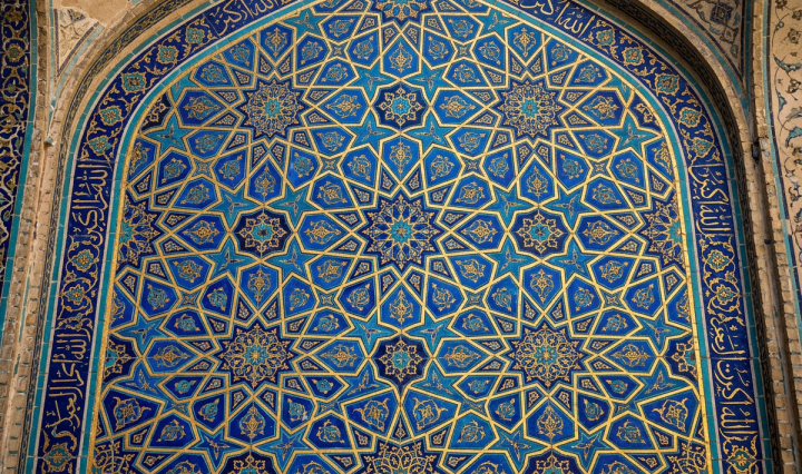 Islamic geometric tilework with blue, gold, and turquoise stars and floral patterns and Arabic calligraphy framing the design.